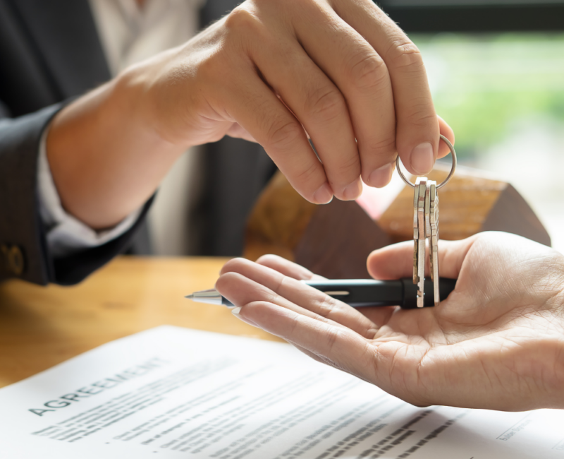 Mano di un avvocato che lascia un paio di chiavi di casa in un'altra mano